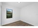 Simple bedroom with hardwood floors and a window offering natural light at 17250 Lake Worth Blvd, Port Charlotte, FL 33948