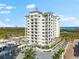 An aerial view of a modern condo building with a gated entrance and pool at 2050 Benjamin Franklin Dr # B304, Sarasota, FL 34236