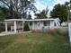 Charming light blue house with a carport, American flag, and well-maintained lawn at 210 Briggs Ct, Sarasota, FL 34237