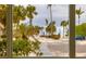 View of tropical landscaping with palm trees and a blue car parked nearby at 2100 Benjamin Franklin Dr # 108, Sarasota, FL 34236