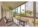 Relaxing screened porch with patio furniture and view of the pool at 2100 Benjamin Franklin Dr # 108, Sarasota, FL 34236