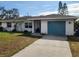 Ranch-style home with teal garage door and landscaped lawn at 2510 Parma St, Sarasota, FL 34231