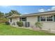 Side view of tan house with green accents and a well-manicured lawn at 2621 Golf Course Dr # 401, Sarasota, FL 34234