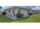 Corner view of a tan house with green accents and neatly landscaped yard at 2621 Golf Course Dr # 401, Sarasota, FL 34234