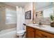 Well-lit bathroom featuring a shower-tub combo, a tiled backsplash, and wood cabinets at 2885 Arrowhead Rd, Venice, FL 34293