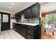 Modern kitchen with dark cabinetry, quartz countertops, and stainless steel appliances at 2885 Arrowhead Rd, Venice, FL 34293