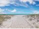 Beach path to pristine shoreline with umbrellas and lounge chairs at 3060 Grand Bay Blvd # 113, Longboat Key, FL 34228