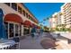 Outdoor patio area with tables and umbrellas at 3060 Grand Bay Blvd # 113, Longboat Key, FL 34228