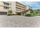 Condo building entrance with a covered portico and meticulously landscaped grounds at 3080 Grand Bay Blvd # 544, Longboat Key, FL 34228