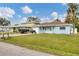 Light blue house with a brown roof, and a grassy yard at 3231 Yorktown St, Sarasota, FL 34231