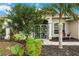 Front entrance with lush tropical landscaping and a screened porch at 3506 Culpepper Ter, North Port, FL 34286