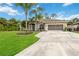 Single-story house with palm trees, landscaped lawn, and a large driveway at 3506 Culpepper Ter, North Port, FL 34286