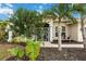 Front entrance with lush tropical landscaping and a screened porch at 3506 Culpepper Ter, North Port, FL 34286