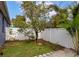 Small grassy backyard area with a tree and a white fence at 363 64Th Avenue E Cir, Bradenton, FL 34203