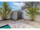 Tan shed with dark brown doors in a backyard with palm trees and a pool at 363 64Th Avenue E Cir, Bradenton, FL 34203