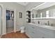 Spa-like bathroom featuring double sinks, a large mirror, and a walk-in closet at 363 64Th Avenue E Cir, Bradenton, FL 34203