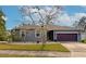 Gray one-story house with purple garage door and landscaped yard at 363 64Th Avenue E Cir, Bradenton, FL 34203