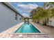 Long, narrow pool with gray patio and tropical landscaping at 363 64Th Avenue E Cir, Bradenton, FL 34203