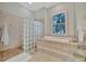 Bathroom with a soaking tub and glass block shower at 3843 E 59 Avenue Cir, Ellenton, FL 34222