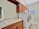 Laundry room with sink, washer, dryer, and wood cabinets at 3843 E 59 Avenue Cir, Ellenton, FL 34222