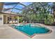 Enclosed pool and spa with covered patio and tropical landscaping at 3843 E 59 Avenue Cir, Ellenton, FL 34222