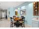 Bright dining room with light blue walls, wood table, and wine storage at 3922 Wildgrass Pl, Parrish, FL 34219