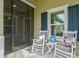 Screened porch with rocking chairs and view of the front yard at 3922 Wildgrass Pl, Parrish, FL 34219