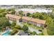 Complex of apartment buildings, pool, and surrounding landscape in aerial view at 3987 Maceachen Blvd # 123, Sarasota, FL 34233