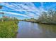 Tranquil canal view with lush vegetation at 4027 Siren Rd, Venice, FL 34293