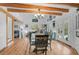 Bright dining room features hardwood floors, exposed beams, and a rustic dining table at 4027 Siren Rd, Venice, FL 34293