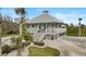 Two-story home with a metal roof, large deck, and landscaping at 4027 Siren Rd, Venice, FL 34293