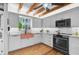 Modern kitchen with exposed beams, copper sink, and wooden floors at 4027 Siren Rd, Venice, FL 34293