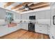 Modern kitchen with exposed beams, copper sink, and wooden floors at 4027 Siren Rd, Venice, FL 34293