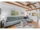 Living room with sectional sofa, hardwood floors, and exposed beams at 4027 Siren Rd, Venice, FL 34293