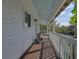 Long porch with wooden floors and white railings at 4027 Siren Rd, Venice, FL 34293