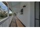 Long porch with wooden floors and white railings at 4027 Siren Rd, Venice, FL 34293