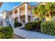 Two-story condo building with lush landscaping and a walkway at 4202 Caddie E Dr # 102, Bradenton, FL 34203