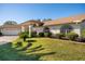 White house with brown roof, arched entryway and nicely landscaped lawn at 4512 Spring Flower Ct, Sarasota, FL 34233