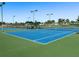 Blue tennis court with green perimeter and lighting at 4608 Halls Mill Xing, Ellenton, FL 34222