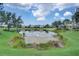 Scenic pond view with lush landscaping and a row of homes in the background at 4826 Maymont Park Cir, Bradenton, FL 34203