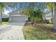 Single-story home with gray siding, attached garage, and landscaped yard at 5007 Elmhurst Ln, Palmetto, FL 34221