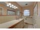 Retro bathroom with light beige tile, shower, and vintage vanity at 5117 6Th Avenue W Dr, Bradenton, FL 34209