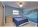 Bedroom with ocean mural, ceiling fan, and double dresser at 5117 6Th Avenue W Dr, Bradenton, FL 34209