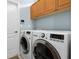 Bright laundry room with LG washer and dryer, and wood cabinets at 5133 Cantabria Crst, Sarasota, FL 34238