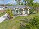 Green house with gray roof, landscaping, and driveway at 5375 Joslyn Ter, Port Charlotte, FL 33981