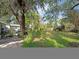 Lush backyard surrounded by mature trees with brick pavers and greenery leading to the home at 5411 9Th E St, Bradenton, FL 34203