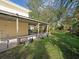 Backyard with a covered outdoor space, a lawn, and plenty of trees at 5411 9Th E St, Bradenton, FL 34203