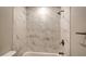 Clean bathroom with a shower/tub combo and marble-look tile at 5687 Milton Ave, Sarasota, FL 34243