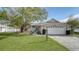 Cute one-story house with a white garage door and green lawn at 5687 Milton Ave, Sarasota, FL 34243