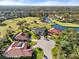 Aerial view showcasing homes, golf course, and lake at 6170 Misty Oaks Dr, Sarasota, FL 34243